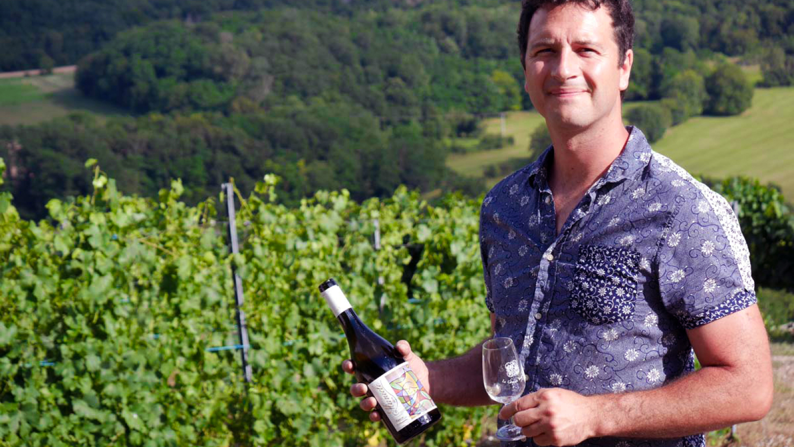 Vigneron dans les vignes avec une bouteille et un verre