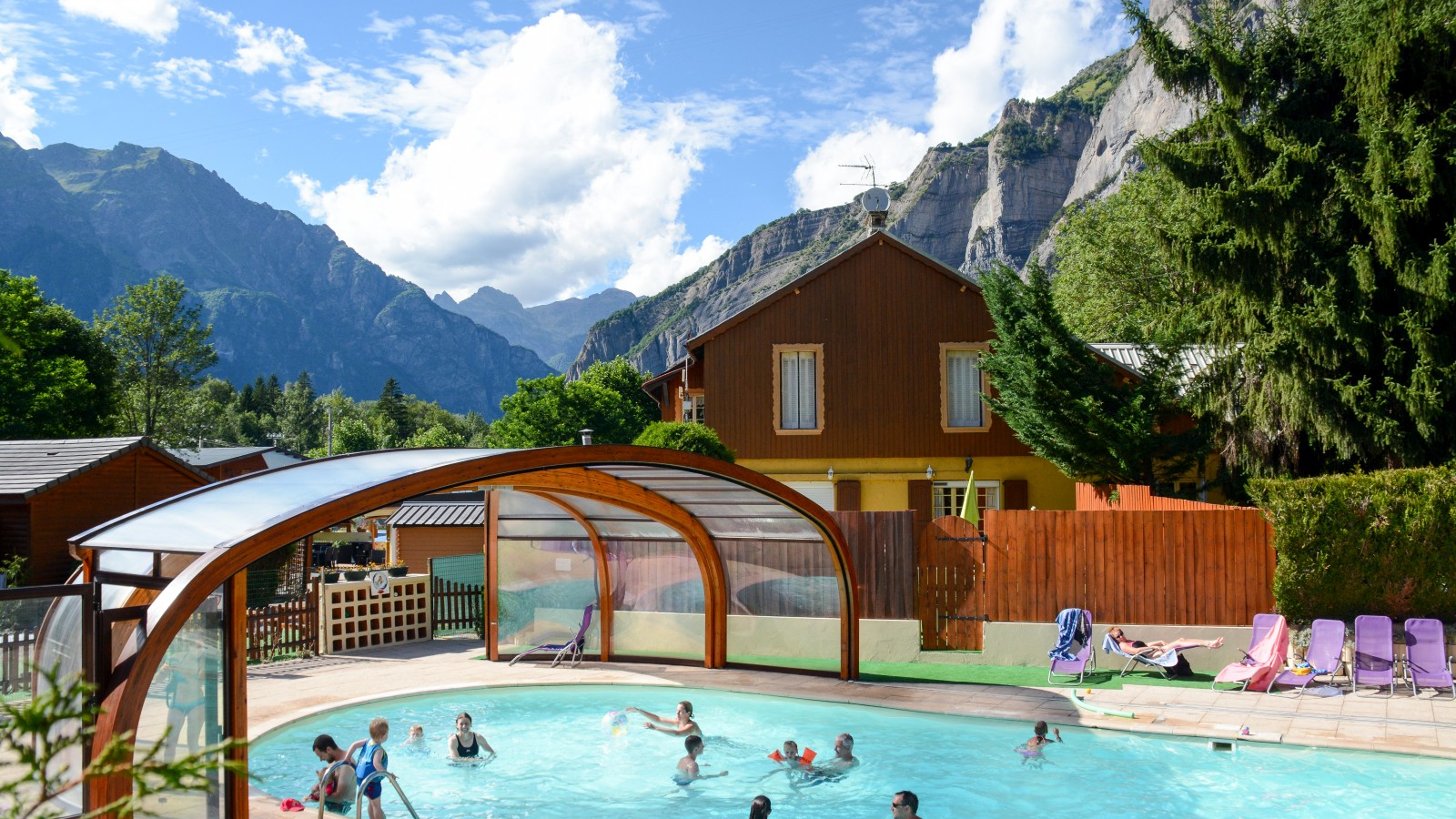 Une piscine extérieure avec terrasse et transats par beau temps