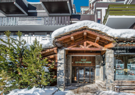 Entrée de l'hôtel avec de la neige et des sapins