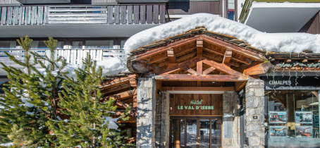 Entrée de l'hôtel avec de la neige et des sapins