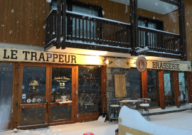 The snow-covered entrance and terrace at night