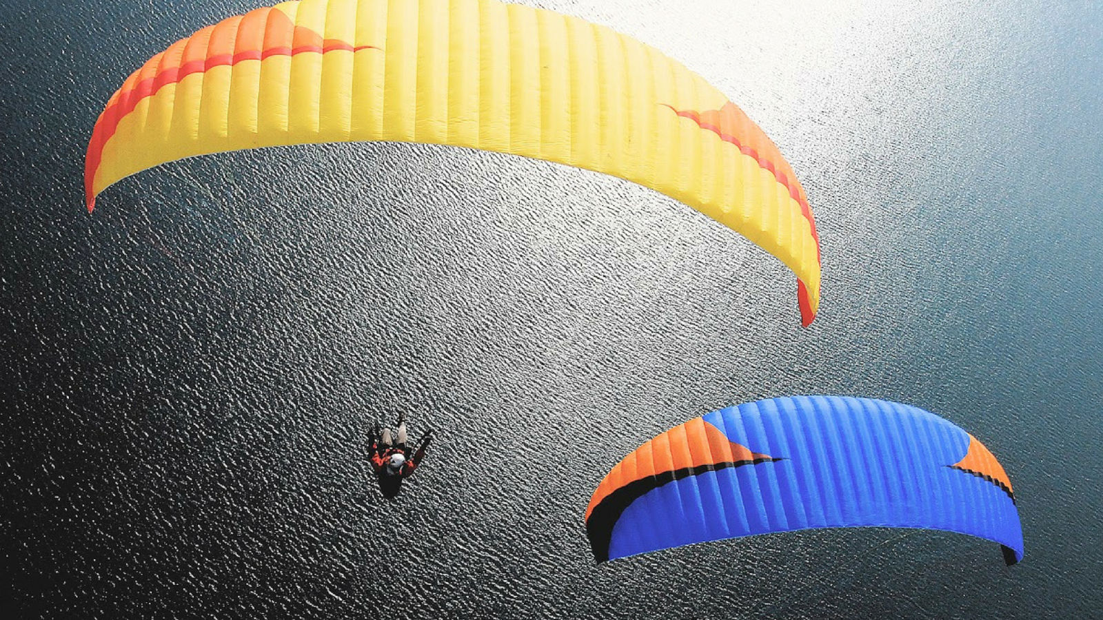 yellow and bluze paragliders above lake Annecy