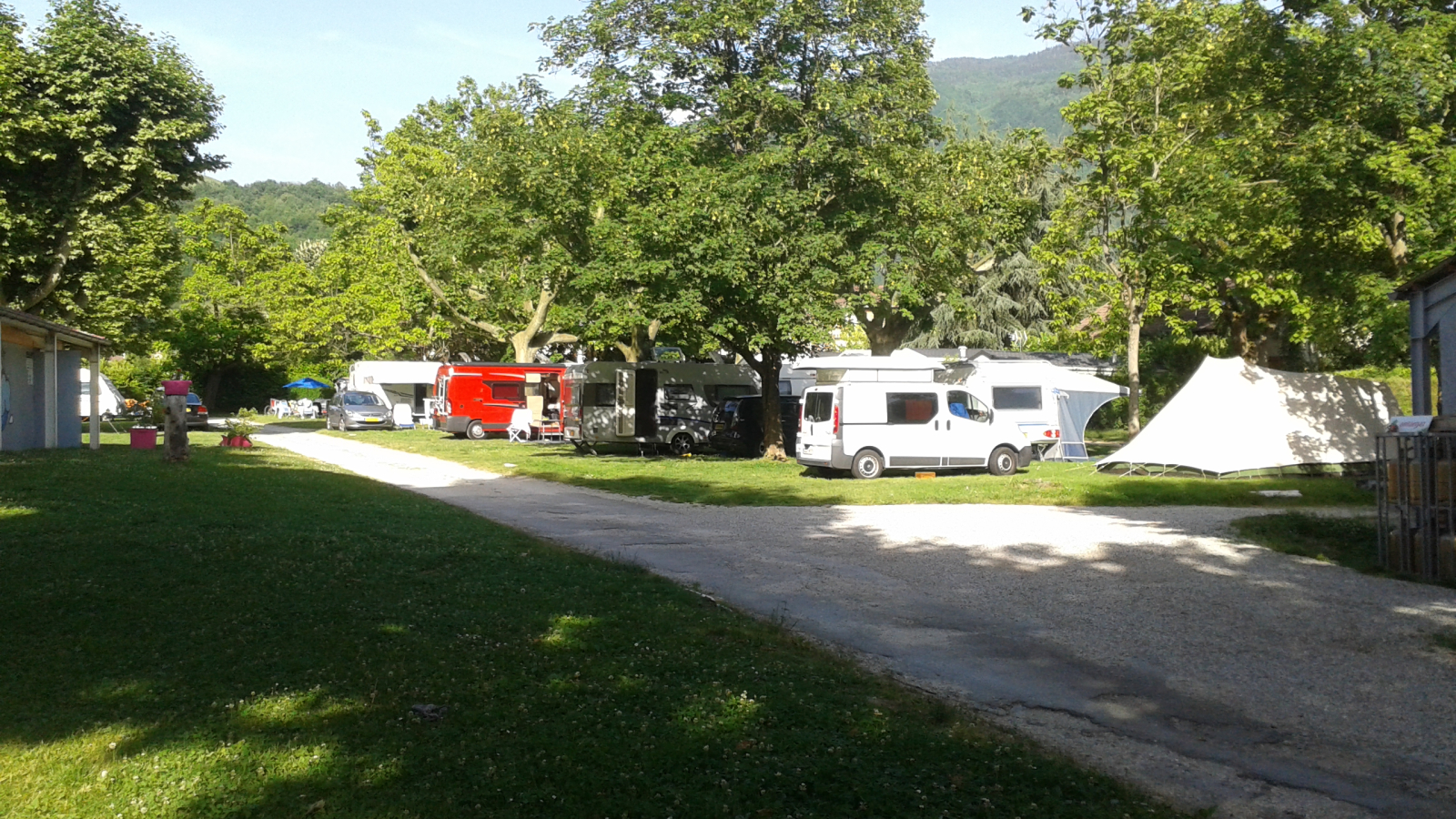 Les emplacements de camping sont aménagés sur un terrain herbeux et ombragés, bordé d'arbres, et desservis par un chemin de terre.