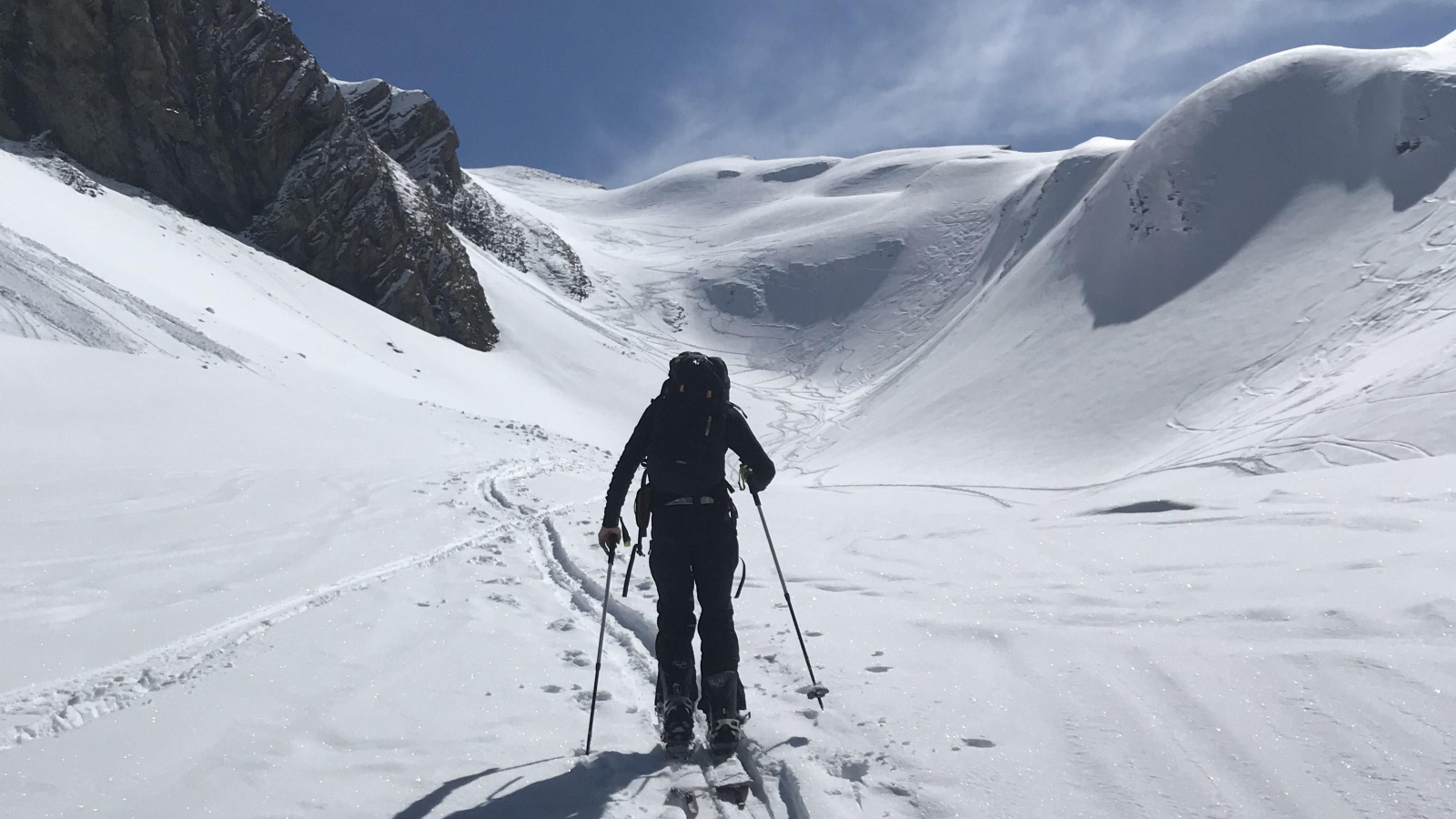 Skieur de randonnée suivant la trace pendant une journée ensoleillée