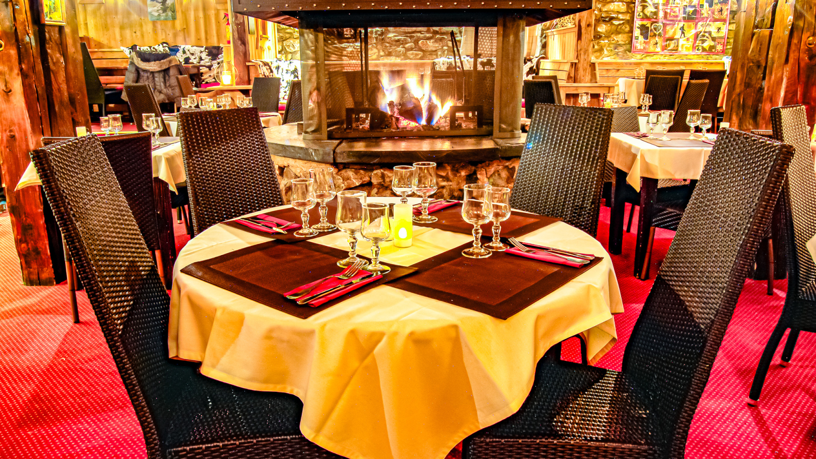 Inside the restaurant overlooking the central fireplace with a table for 4 in the foreground