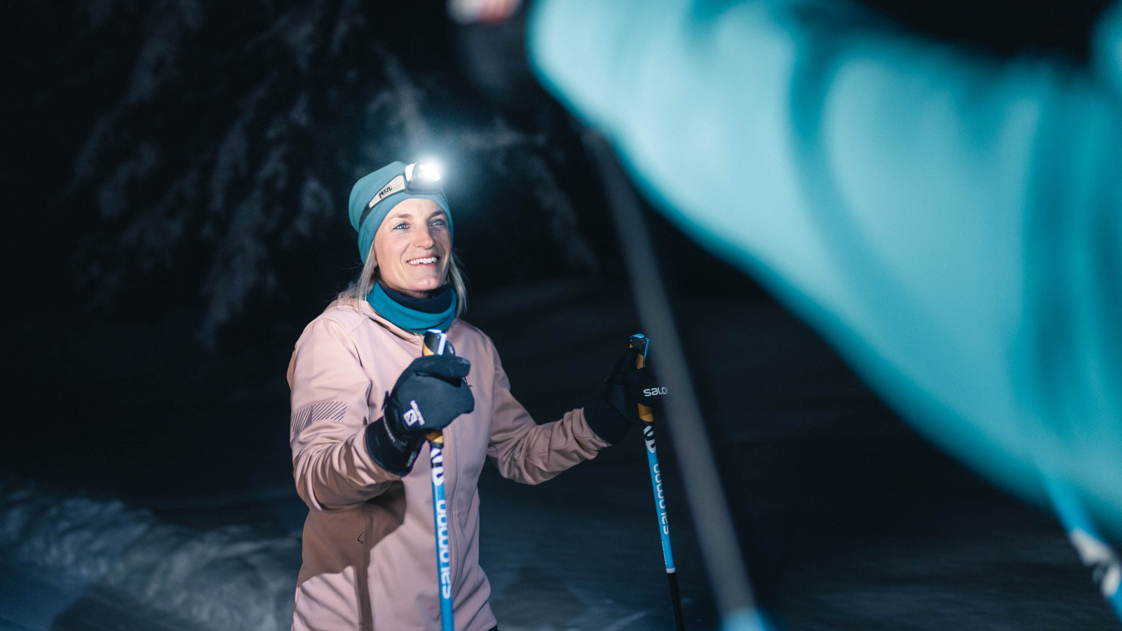 Skieuse portant une lampe frontale sur une piste de ski nordique ouverte en nocturne