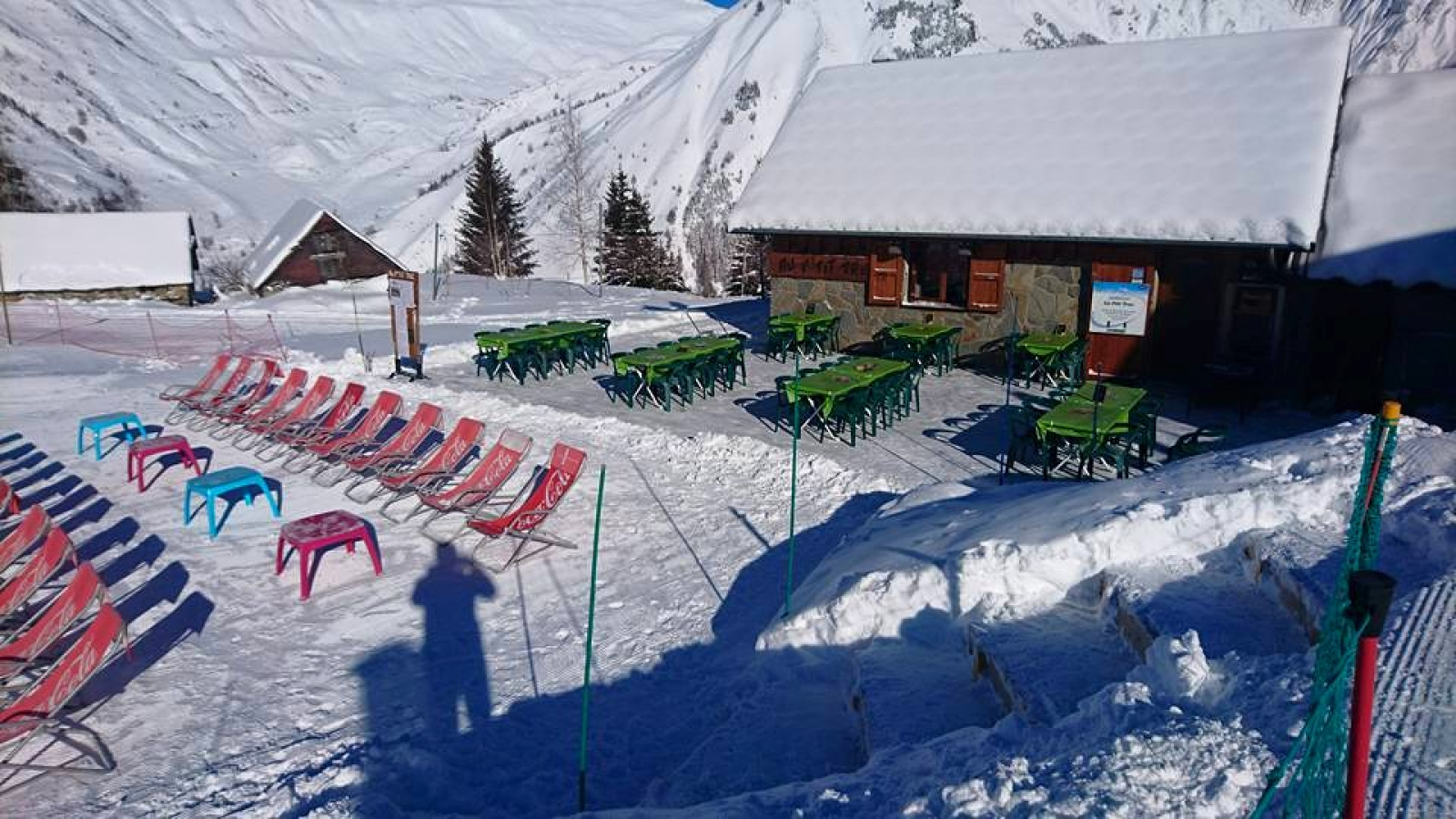 Terrasse du restaurant avec transat et table à manger.