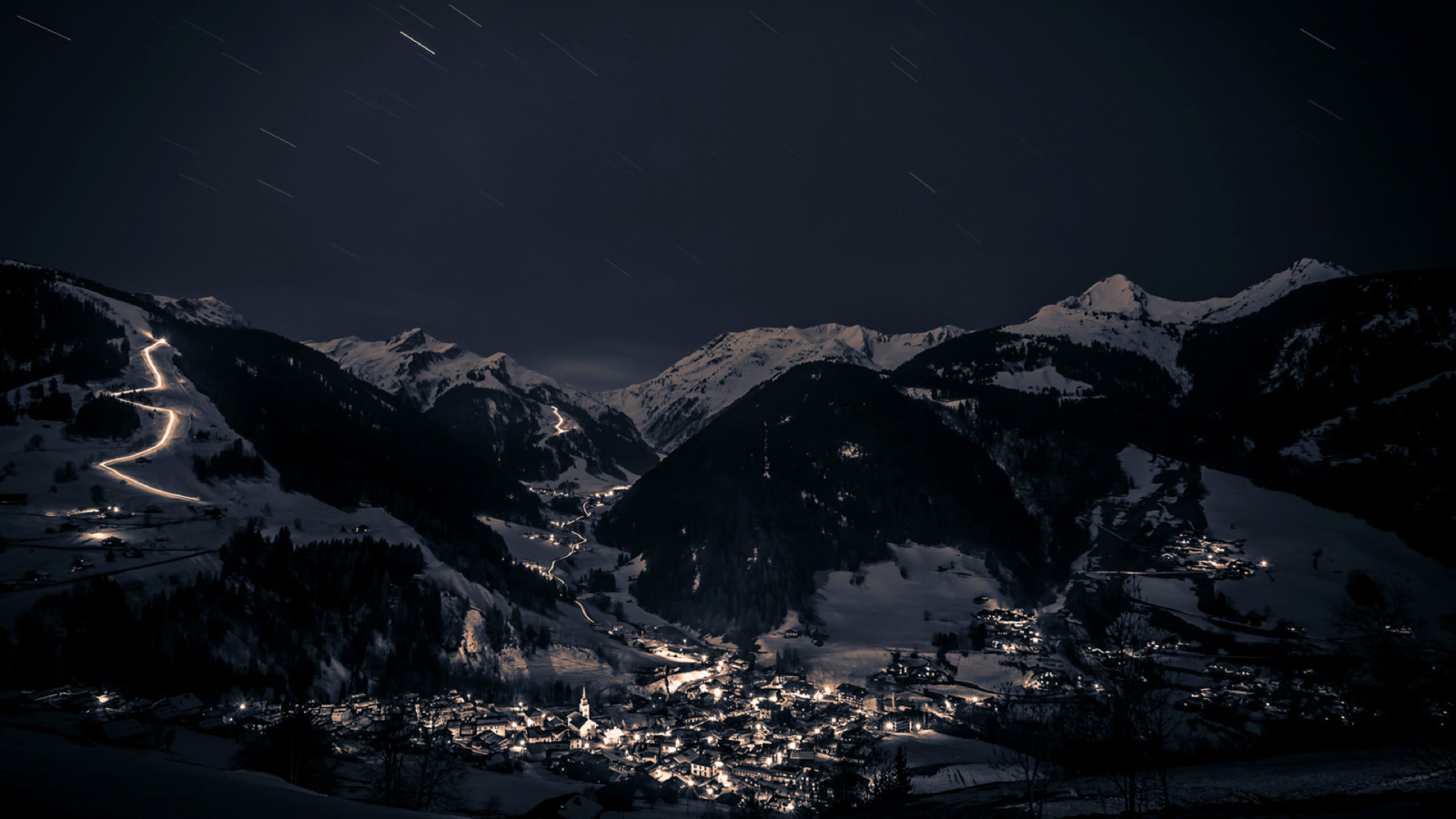 Village d'Arêches en hiver avec descente aux flambeaux sur la piste du Grand Mont