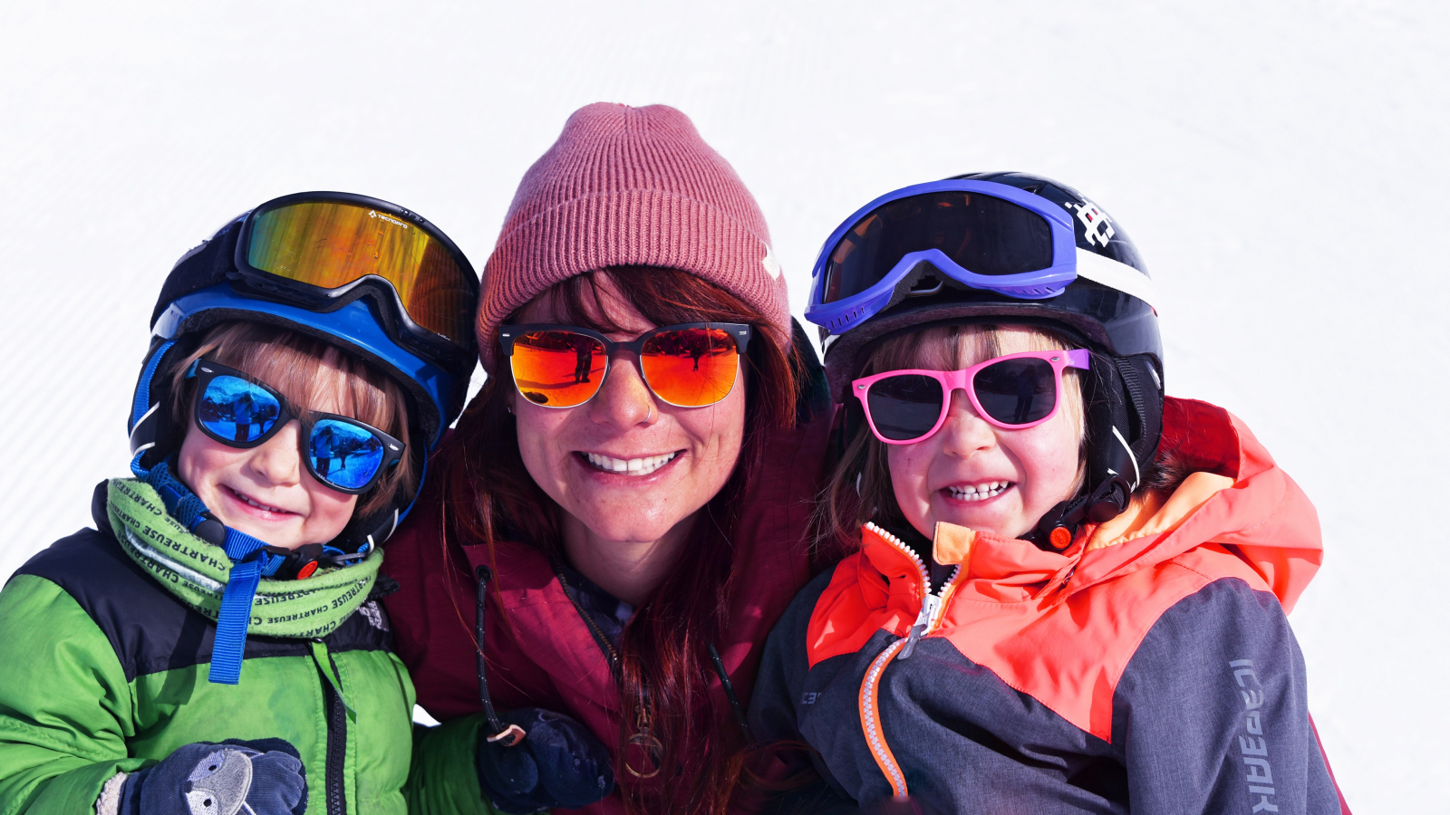 Photo d'une animatrice du club enfants avec deux enfants dans un décor hivernal