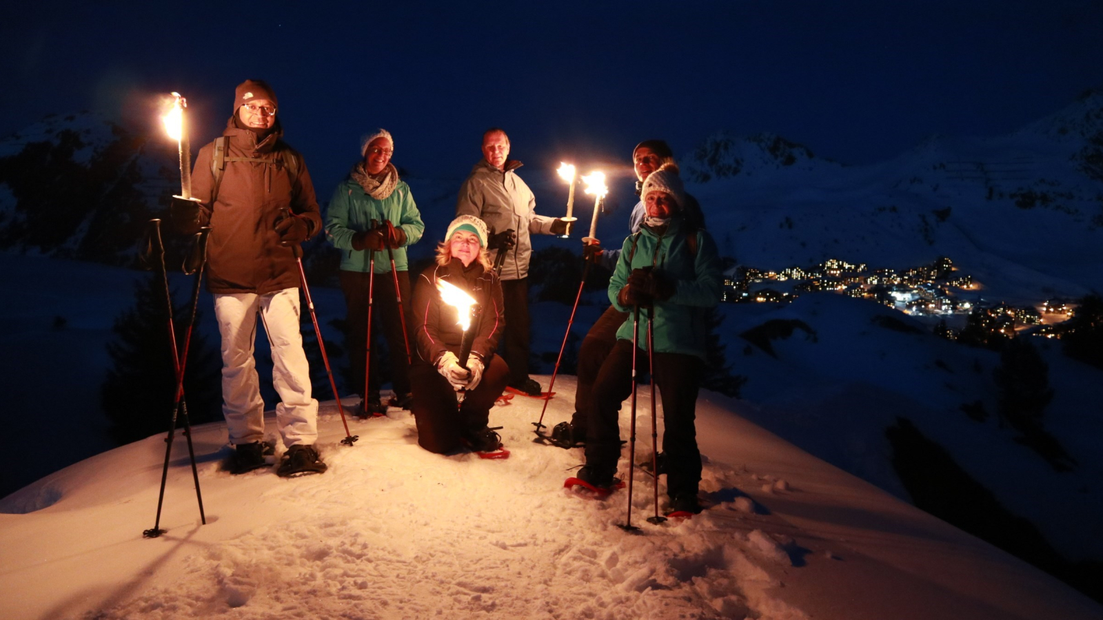 group with torches on evening snowshoe hike