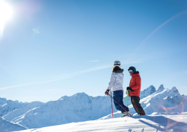 Un couple de skieurs sur le Crey du Quart, admirant la vue sur les Aiguilles d'Arves depuis Valloire