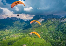 three paragliders mountain view