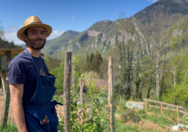 Arnaud dans son jardin papillon avec les montagnes en arrière plan