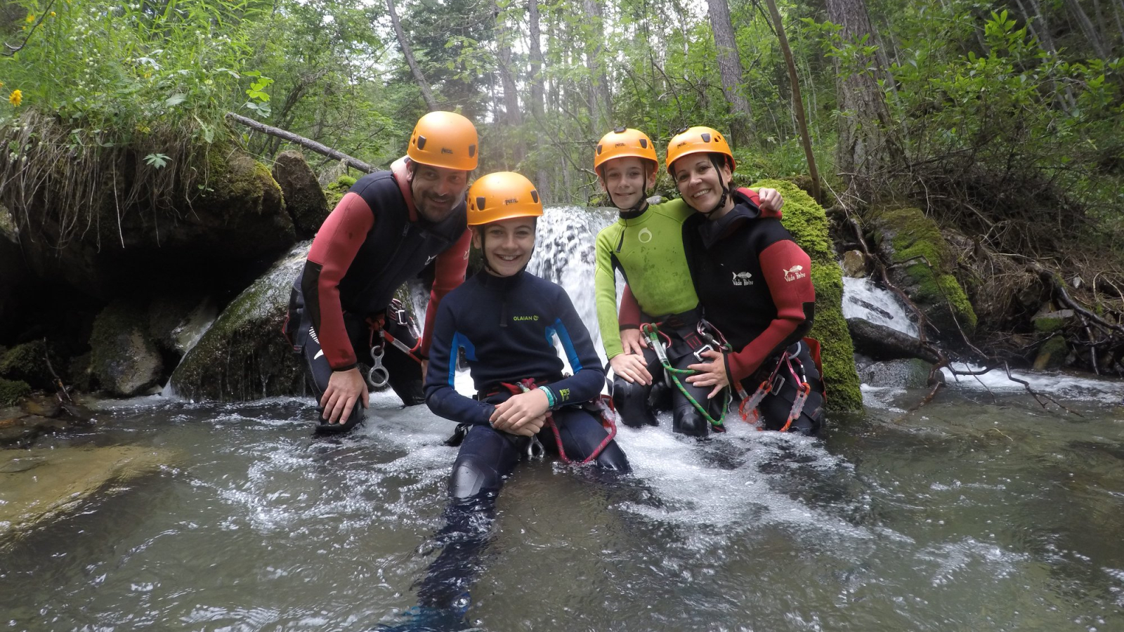 Famille et moniteur de canyoning regroupés dans la rivière à Valloire