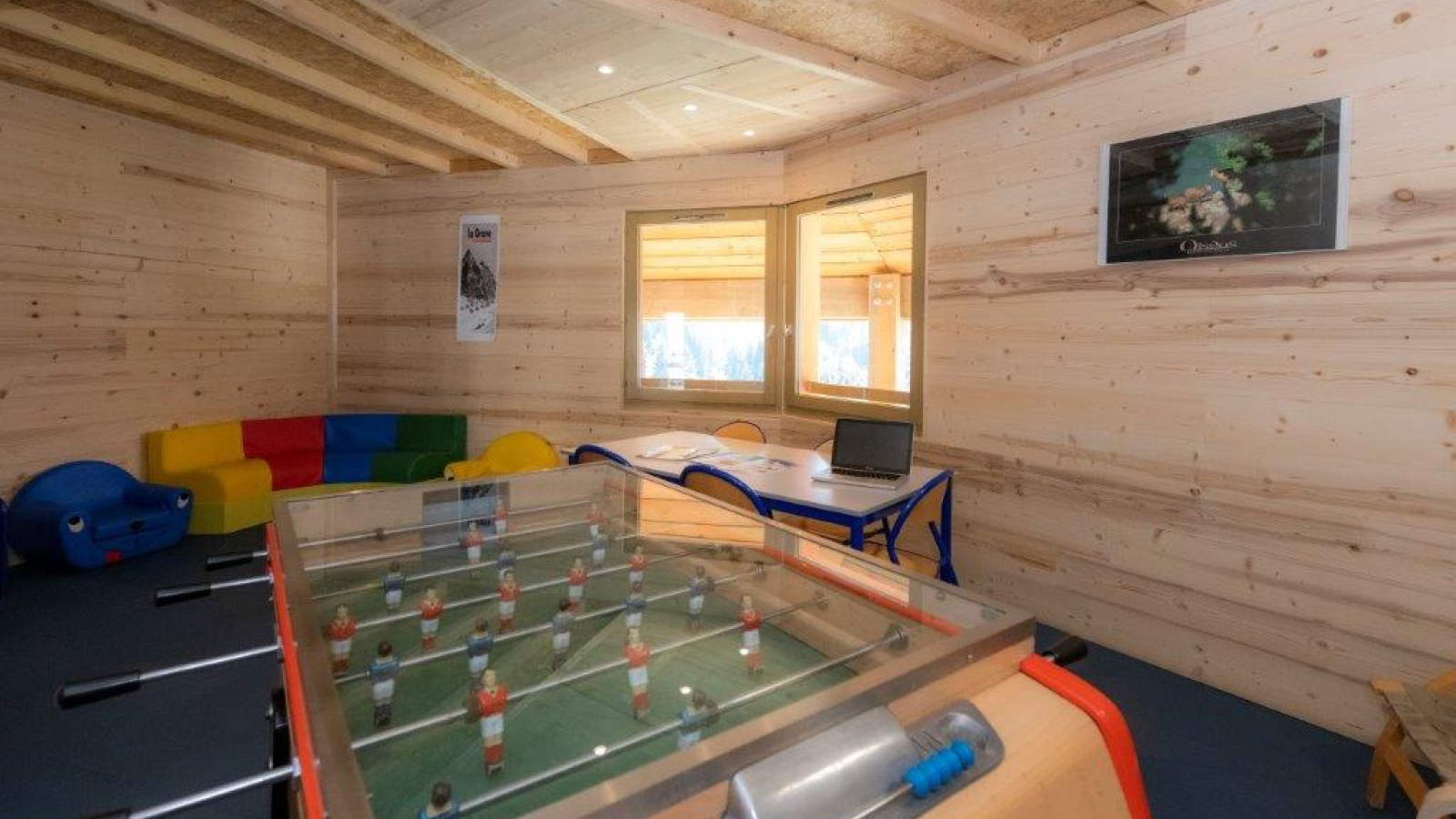 Salle de jeux accessible par les clients de la résidence avec un billard, une table et des chaises, divers fauteuils.