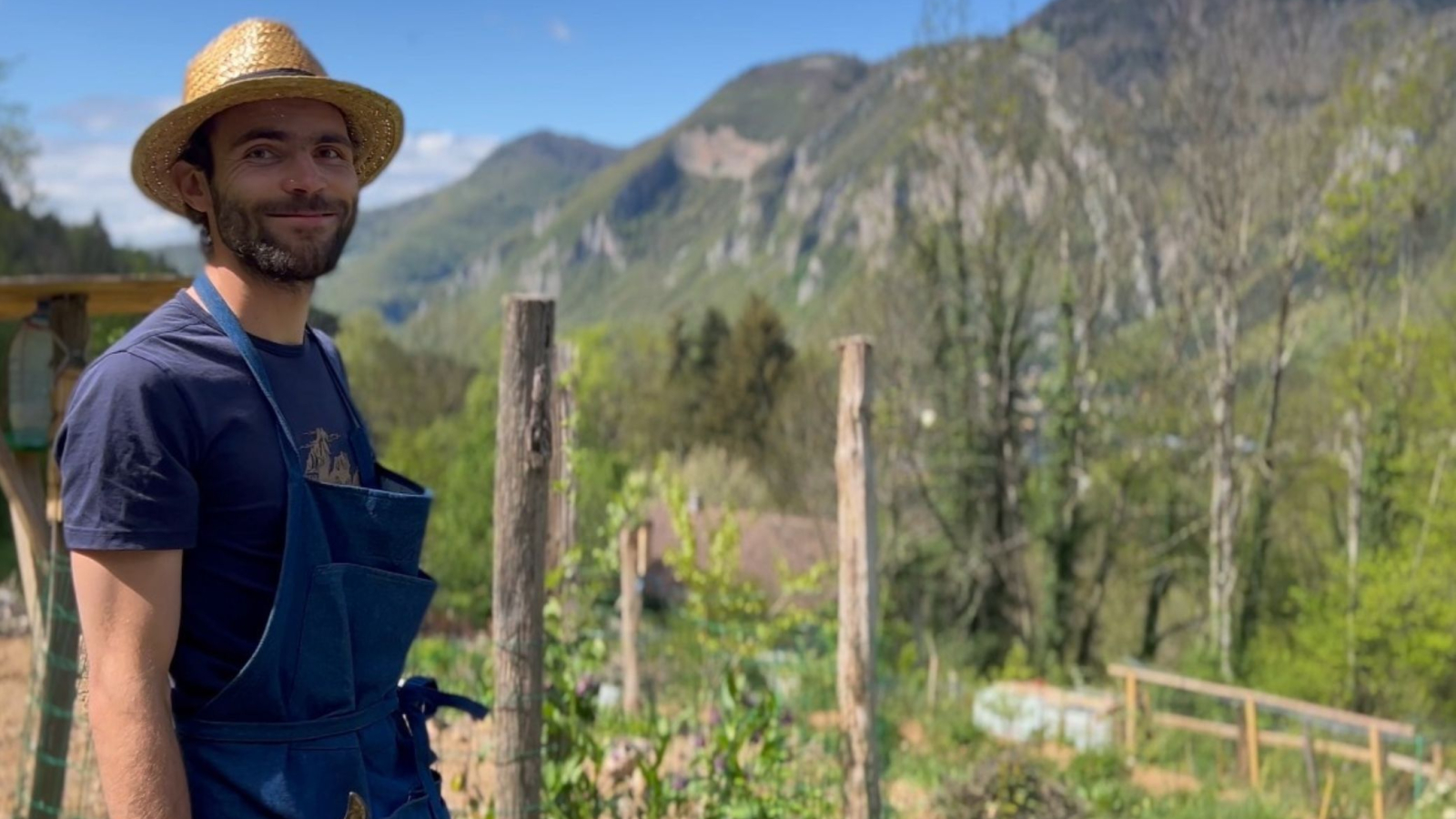 Arnaud dans son jardin papillon avec les montagnes en arrière plan