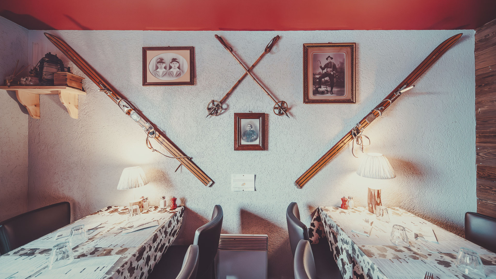 Salle du restaurant avec sur le mur de vieux skis en bois en décoration