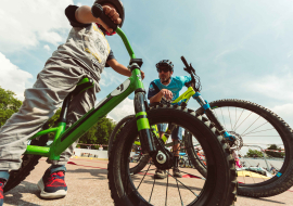 Quelques enfants embarqués sur leurs petits vélos s'apprêtent à suivre le stage