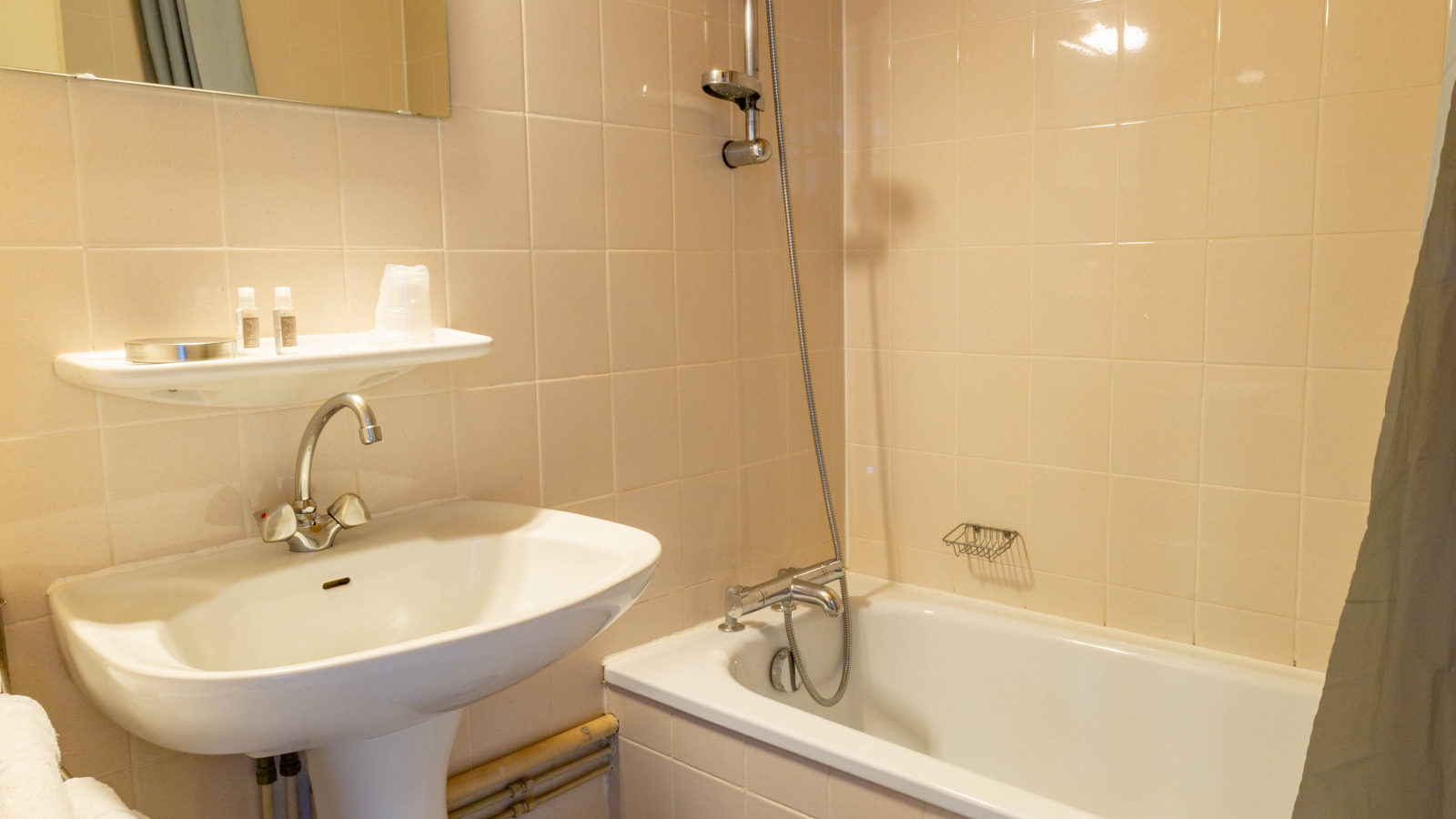 Salle de bains avec baignoire, lavabo, miroir