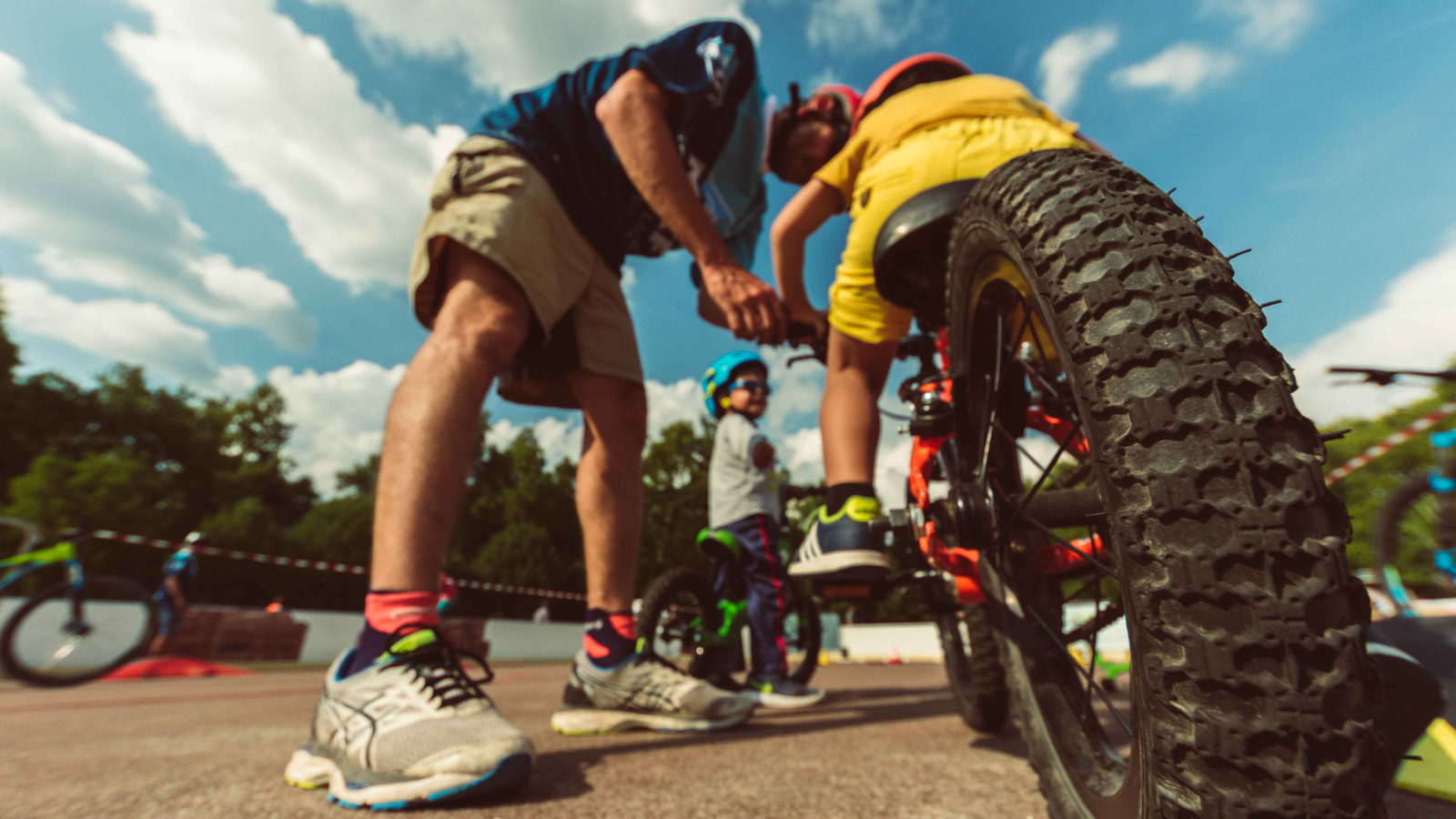 Un moniteur de l'école Natura Vélo enseigne quelque chose à un jeune participant