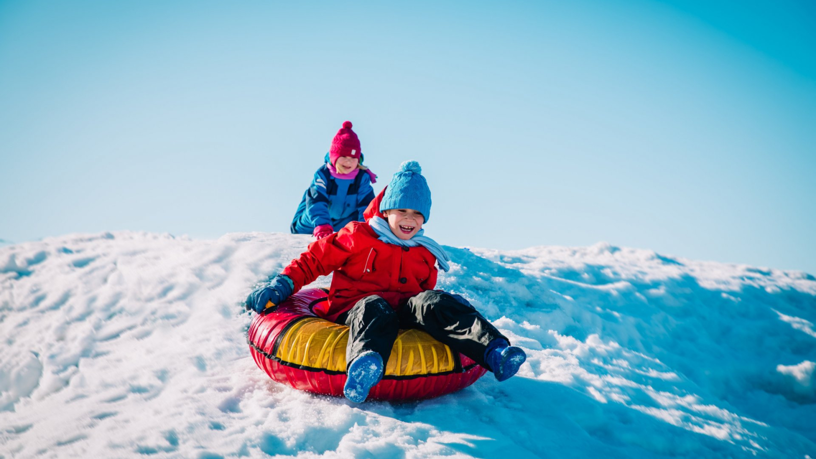 Enfants qui jouent sur une bouée gonflable sur la neige